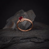 Anillo de compromiso con rubí natural de .50ct corte brillante y 16 cristales elaborado en oro rosa de 14k