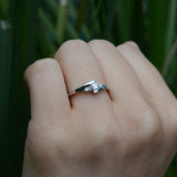 Anillo de compromiso con moissanita de .20ct corte brillante y 2 cristales laterales elaborado en oro blanco de 10k