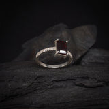 Anillo de compromiso con granate natural corte esmeralda y 12 diamantes laterales elaborado en plata .970