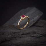 Anillo de compromiso con rubí natural de .50ct corte brillante y 32 diamantes naturales laterales elaborado en oro amarillo de 14k