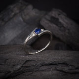 Anillo de compromiso con zafiro natural de .20ct corte brillante y 2 cristales elaborado en oro blanco de 10k