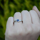 Anillo de compromiso con zafiro natural de .20ct corte brillante y 2 cristales elaborado en oro blanco de 10k