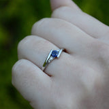 Anillo de compromiso con zafiro natural de .20ct corte brillante y 2 cristales elaborado en oro blanco de 10k