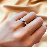 Anillo de compromiso con rubí natural de .20ct corte brillante y 2 cristales elaborado en oro blanco de 10k