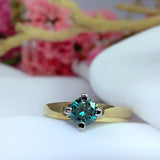 Anillo con diamante azul natural central de .50ct corte brillante en oro amarillo y blanco de 14k