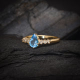 Anillo de compromiso con topacio corte gota y 6 diamantes laterales elaborado en oro amarillo de 14 kilates
