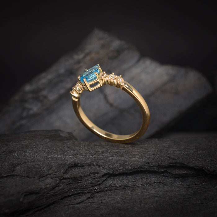 Anillo de compromiso con topacio corte gota y 6 diamantes laterales elaborado en oro amarillo de 14 kilates