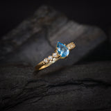 Anillo de compromiso con topacio corte gota y 6 diamantes laterales elaborado en oro amarillo de 14 kilates
