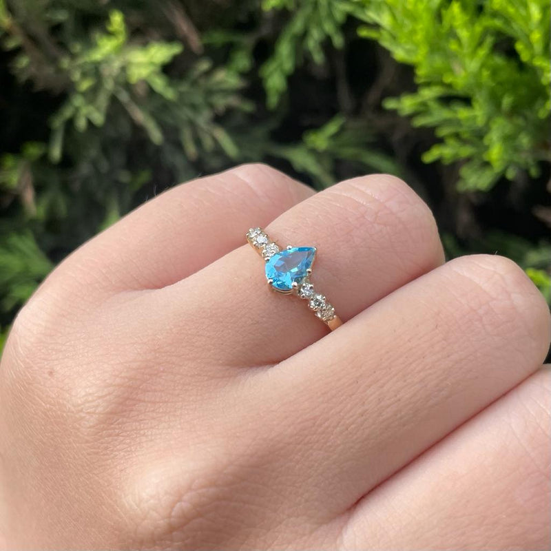 Anillo de compromiso con topacio corte gota y 6 diamantes laterales elaborado en oro amarillo de 14 kilates