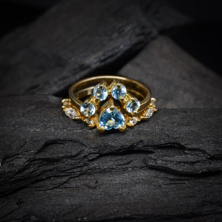 Anillo de compromiso con topacios y diamantes naturales elaborado en oro amarillo de 18 kilates