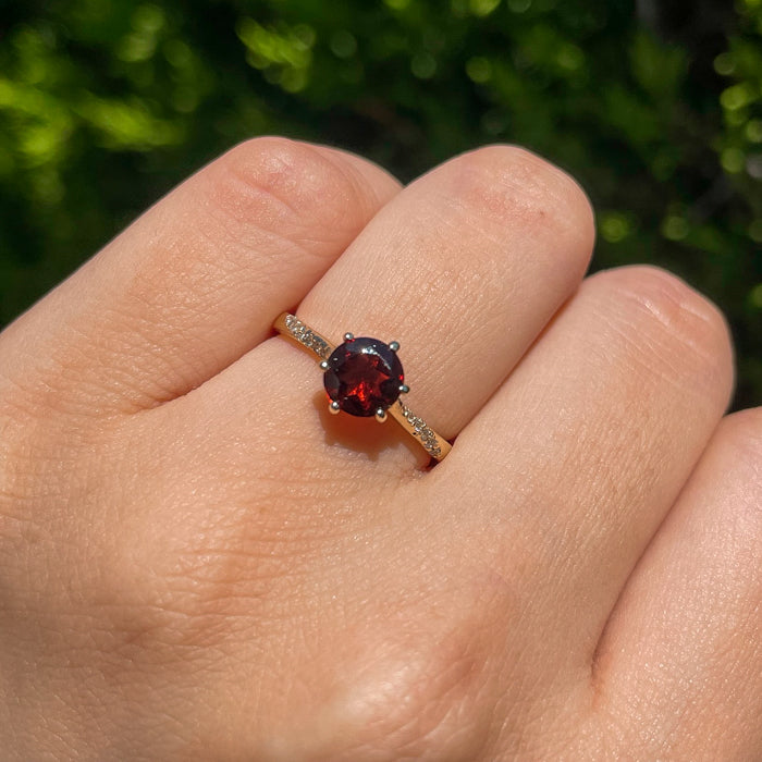 Anillo de compromiso con granate natural y 12 diamantes naturales laterales realizado en oro amarillo de 14 kilates