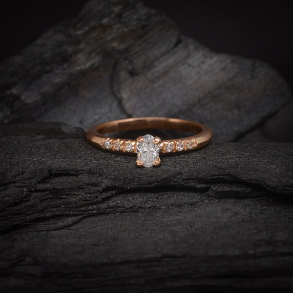 Anillo de compromiso con diamante natural de .30ct corte oval y 6 diamantes laterales elaborado en oro rosa de 14k