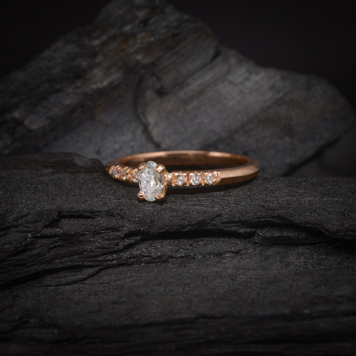 Anillo de compromiso con diamante natural de .30ct corte oval y 6 diamantes laterales elaborado en oro rosa de 14k