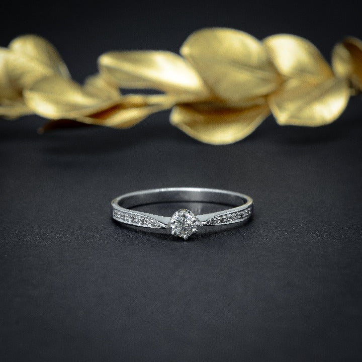 Anillo de compromiso con diamante natural de .10ct y 10 diamantes laterales elaborado en oro blanco de 18 kilates