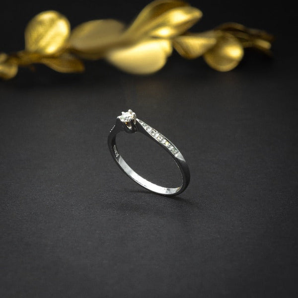 Anillo de compromiso con diamante natural central de .10ct y 10 diamantes naturales laterales elaborado en oro blanco de 18 kilates