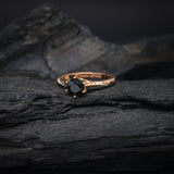 Anillo de compromiso con diamante negro natural central de .70ct y 12 diamantes naturales laterales elaborado en oro rosa de 14 kilates