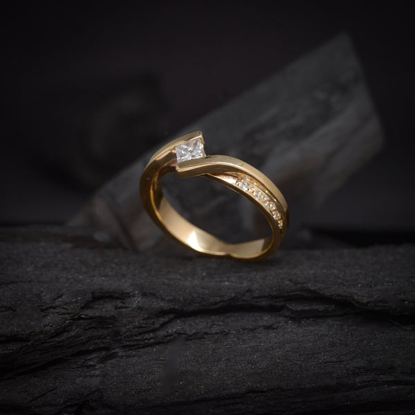 Anillo de compromiso con diamante natural de .20ct corte princesa y 5 diamantes laterales elaborado en oro amarillo de 14 kilates