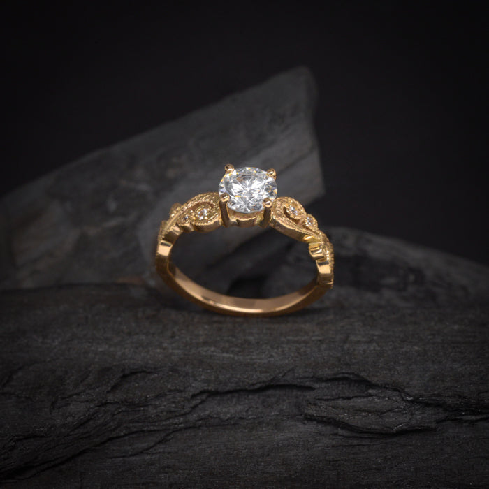 Anillo de compromiso con diamante natural central de .60ct con certificación GIA y 8 diamantes naturales laterales elaborado en oro amarillo de 18 kilates