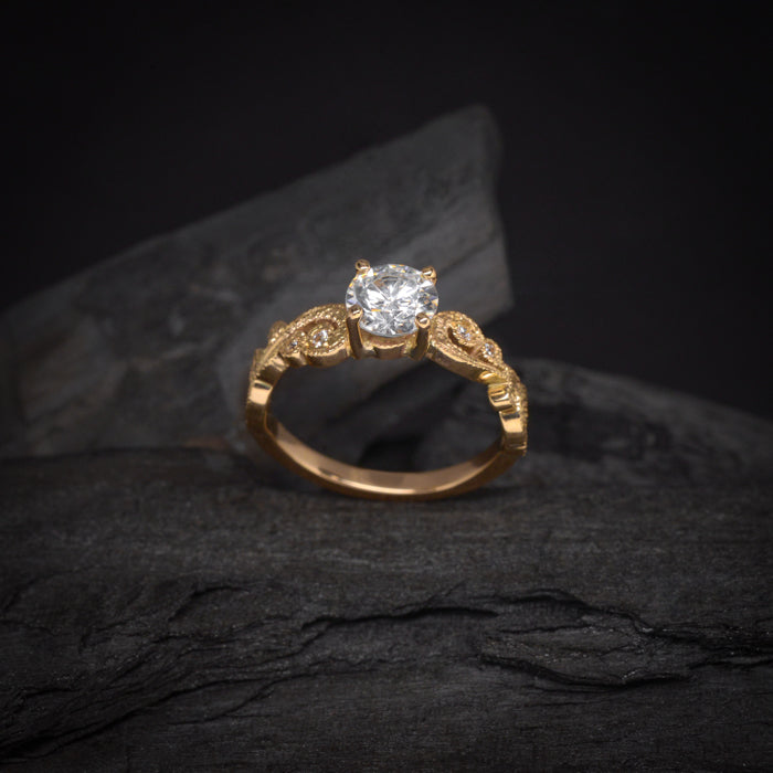 Anillo de compromiso con diamante natural central de .60ct con certificación GIA y 8 diamantes naturales laterales elaborado en oro amarillo de 14 kilates