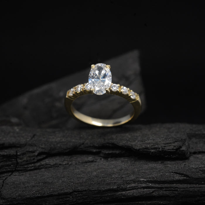 Anillo de compromiso con moissanita oval de 1.5ct con certificado GRA y moissanitas laterales elaborado en oro amarillo de 14 kilates
