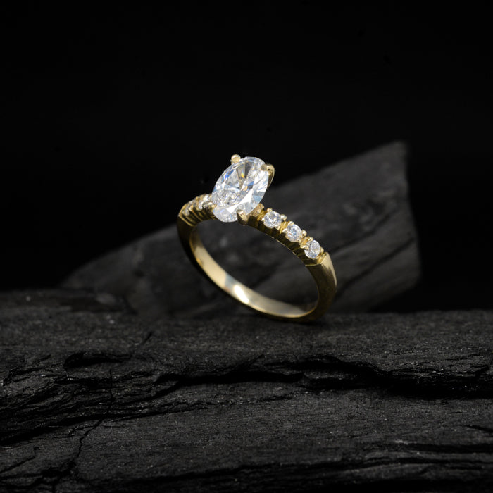 Anillo de compromiso con moissanita oval de 1.5ct con certificado GRA y moissanitas laterales elaborado en oro amarillo de 14 kilates