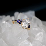 Anillo de compromiso con diamante de laboratorio de 1.5ct corte oval con certificado IGI y 10 zafiros naturales laterales elaborado en oro amarillo de 14k