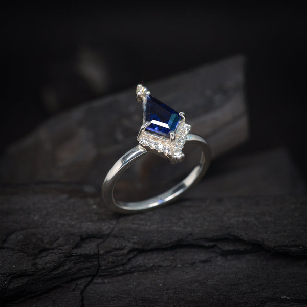 Anillo de compromiso con cristal azul corte papalote y 10 diamantes laterales elaborado en plata .950