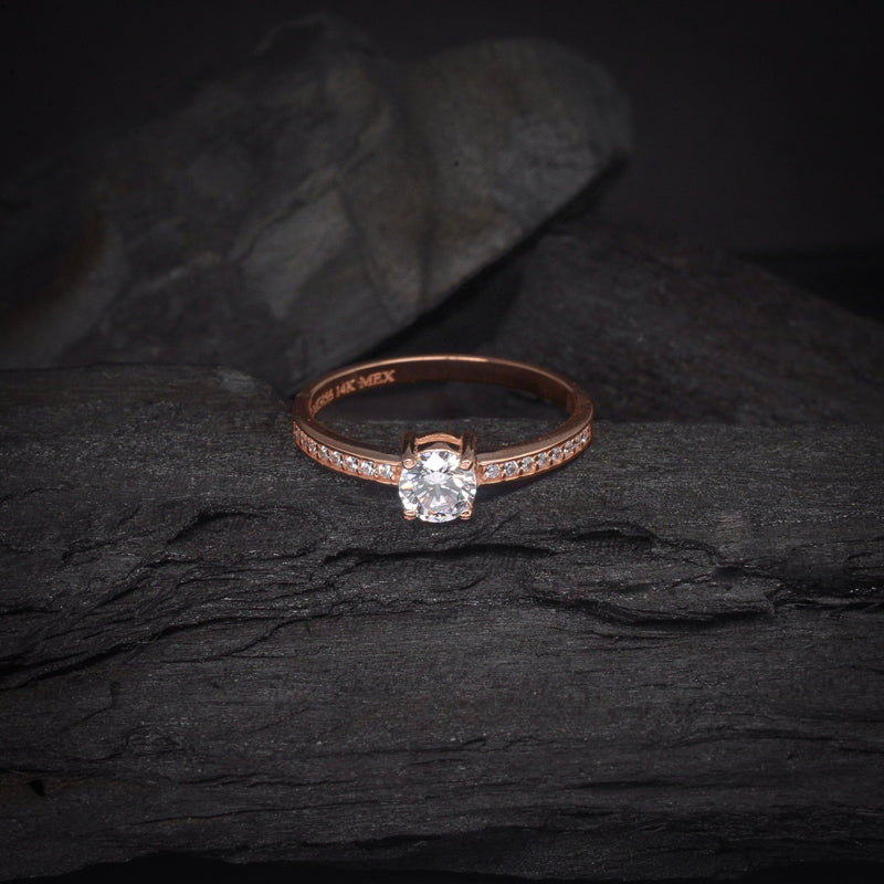 Anillo de compromiso con diamante natural de .50ct y cristales laterales elaborado en oro rosa de 14 kilates