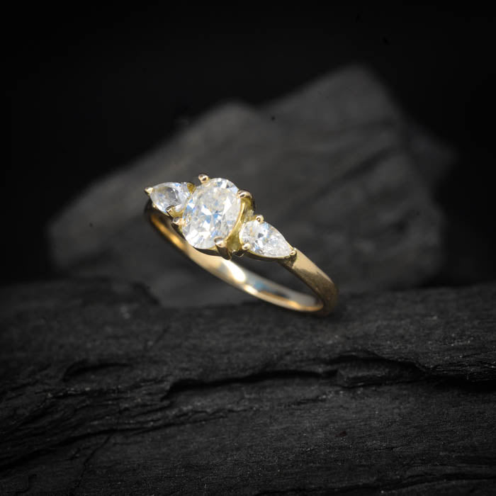Anillo de compromiso con moissanita oval de 1.5ct con certificado GRA y moissanitas laterales elaborado en oro amarillo de 14 kilates