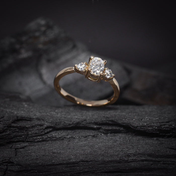 Anillo de compromiso con moissanita de .50ct  con certificado GRA y 2 diamantes laterales elaborado en oro amarillo de 14 kilates