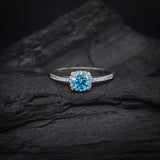 Anillo de compromiso con moissanita azul de .50ct con certificado GRA y cristales laterales elaborado en oro blanco de 10 kilates