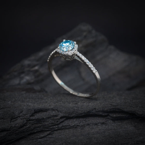 Anillo de compromiso con moissanita azul de .50ct con certificado GRA y 32 diamantes laterales elaborado en oro blanco de 14 kilates