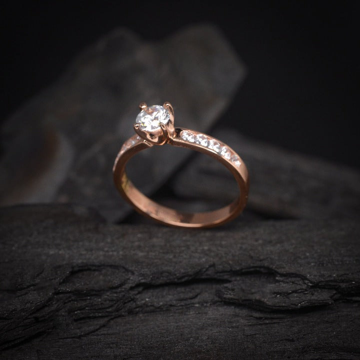 Anillo de compromiso con diamante de laboratorio central de .70ct y cristales laterales elaborado en oro rosa de 14 kilates