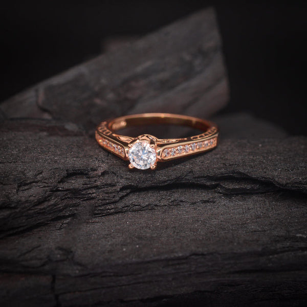 Anillo de compromiso con diamante de laboratorio central de .70ct y cristales laterales elaborado en oro rosa de 18 kilates