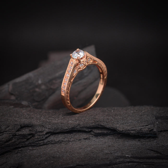 Anillo de compromiso con diamante de laboratorio central de .70ct y cristales laterales elaborado en oro rosa de 18 kilates
