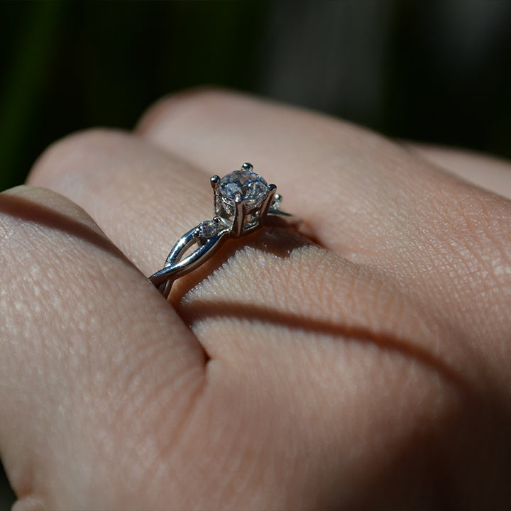 Anillo de compromiso con diamante de laboratorio de .50ct y cristales laterales elaborado en oro blanco de 18 kilates