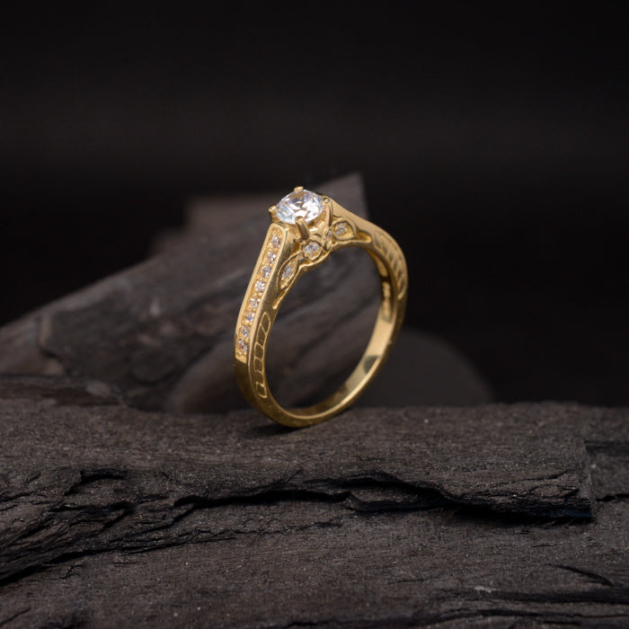 Anillo de compromiso con moissanita de .50ct con certificado GRA y cristales laterales elaborado en oro amarillo de 14 kilates