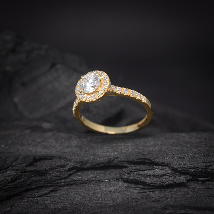 Anillo de compromiso con diamante natural central de .50ct y cristales laterales elaborado en oro amarillo de 14 kilates