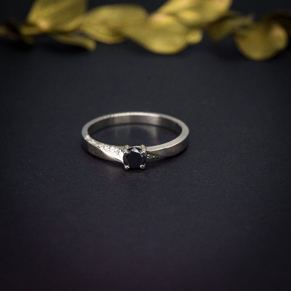 Anillo de compromiso con diamante negro natural de .25ct y 16 diamantes laterales elaborado en oro blanco de 18 kilates