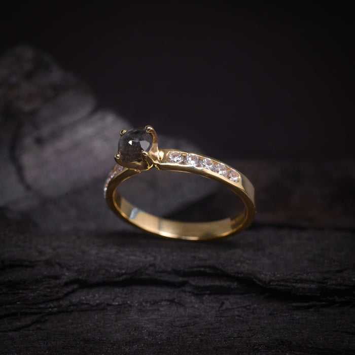 Anillo de compromiso con diamante natural sal y pimienta de .65ct y cristales laterales elaborado en oro amarillo de 14 kilates