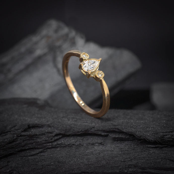 Anillo de compromiso con diamante natural central de .30ct corte gota y 2 diamantes naturales laterales elaborado en oro amarillo de 14 kilates