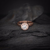 Anillo de compromiso con moissanita de .50ct y cristales laterales elaborado en oro rosa de 14 kilates