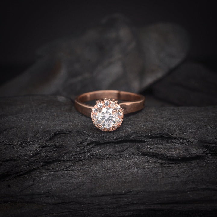 Anillo de compromiso con moissanita de .50ct y cristales laterales elaborado en oro rosa de 14 kilates