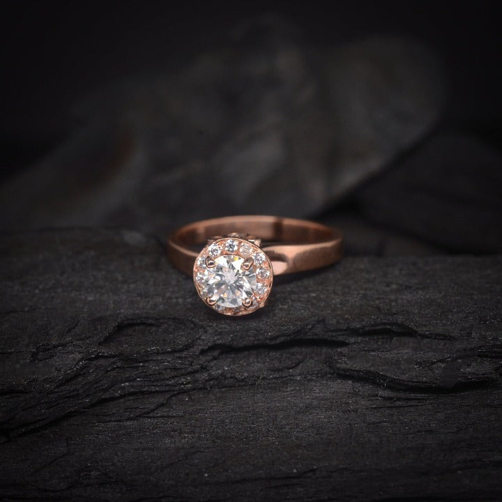 Anillo de compromiso con moissanita de .50ct y cristales laterales elaborado en oro rosa de 14 kilates