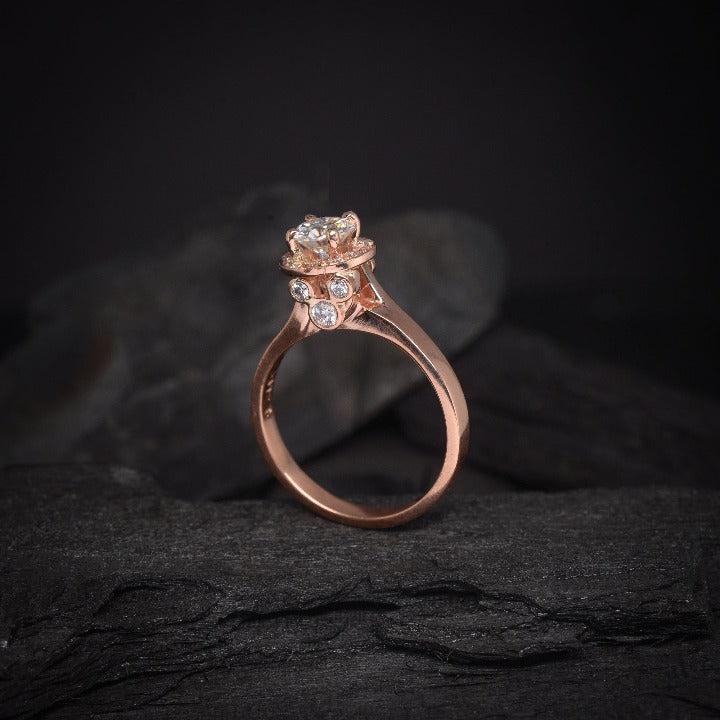 Anillo de compromiso con moissanita de .50ct y cristales laterales elaborado en oro rosa de 14 kilates