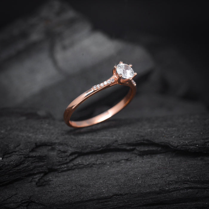 Anillo de compromiso con diamante de laboratorio central de .50ct y cristales realizado en oro rosa de 14 kilates