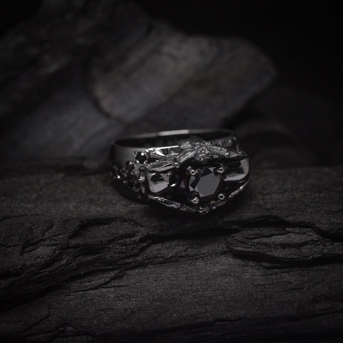 Anillo de compromiso con diamante negro natural central de .50ct y cristales negros laterales elaborado en oro de 18 kilates