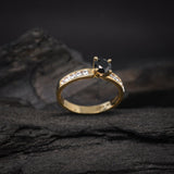Anillo de compromiso con diamante negro natural central de .50ct y cristales laterales elaborado en oro amarillo de 14 kilates
