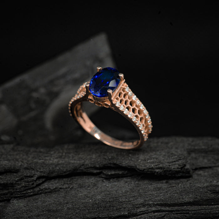 Anillo de compromiso con zafiro natural corte oval y diamantes naturales laterales elaborado en oro rosade 14 kilates