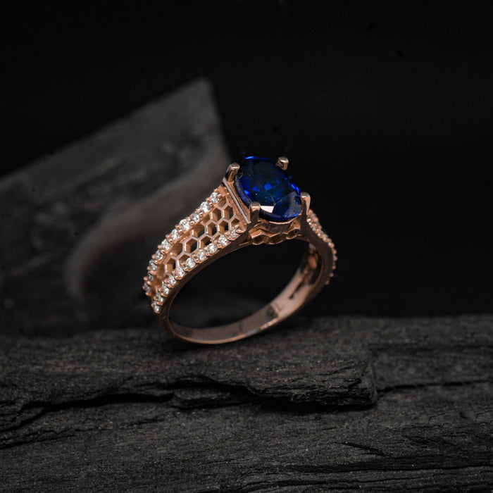Anillo de compromiso con zafiro natural corte oval y diamantes naturales laterales elaborado en oro rosade 14 kilates